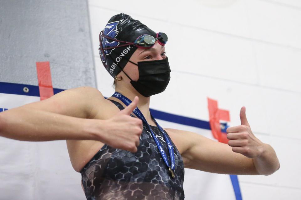 Dover-Sherborn’s Ava Yablonski stands on the podium after taking gold in the 50-yard freestyle during the girls South sectional swim meet at Milford High School on Feb. 12, 2022.