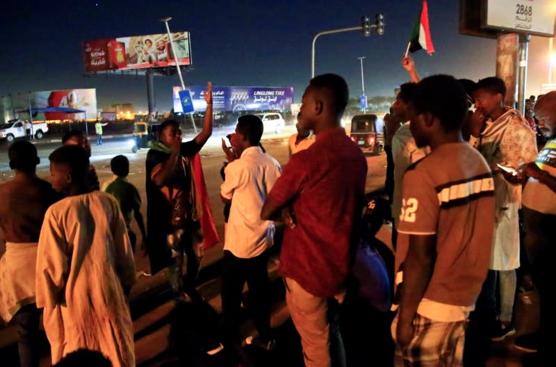 Civilians gather near the area where gunmen opened fire outside buildings used by Sudan's National Intelligence and Security Service in Khartoum