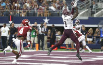 Texas A&M wide receiver Quartney Davis (1) catches a touchdown pass as Arkansas defensive back Jarques McClellion (4) looks on during the second half of an NCAA college football game Saturday, Sept. 28, 2019, in Arlington, Texas. Texas A&M won 31-27. (AP Photo/Ron Jenkins)