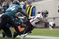 Atlanta Falcons running back Cordarrelle Patterson, right, dives for a touchdown past Jacksonville Jaguars linebacker Myles Jack (44) during the first half of an NFL football game, Sunday, Nov. 28, 2021, in Jacksonville, Fla. (AP Photo/Phelan M. Ebenhack)