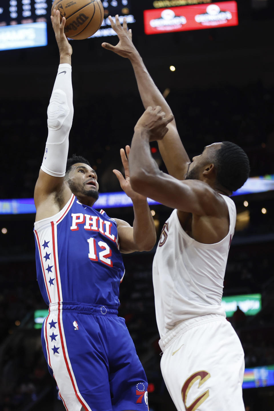 Philadelphia 76ers forward Tobias Harris (12) shoots against Cleveland Cavaliers forward Evan Mobley during the first half of an NBA basketball game Friday, March 29, 2024, in Cleveland. (AP Photo/Ron Schwane)