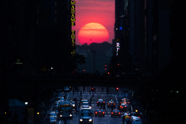 FILE - The sun sets along 42nd Street in Manhattan during an annual phenomenon known as "Manhattanhenge," when the sun aligns perfectly with the city's transit grid, Wednesday, May 29, 2013, in New York. There's still time to catch Manhattanhenge, when the setting sun aligns with the Manhattan street grid and bathes the urban canyons in a rosy glow. The last two Manhattanhenge sunsets of 2022 are Monday and Tuesday, July 11-12. (AP Photo/John Minchillo, File)