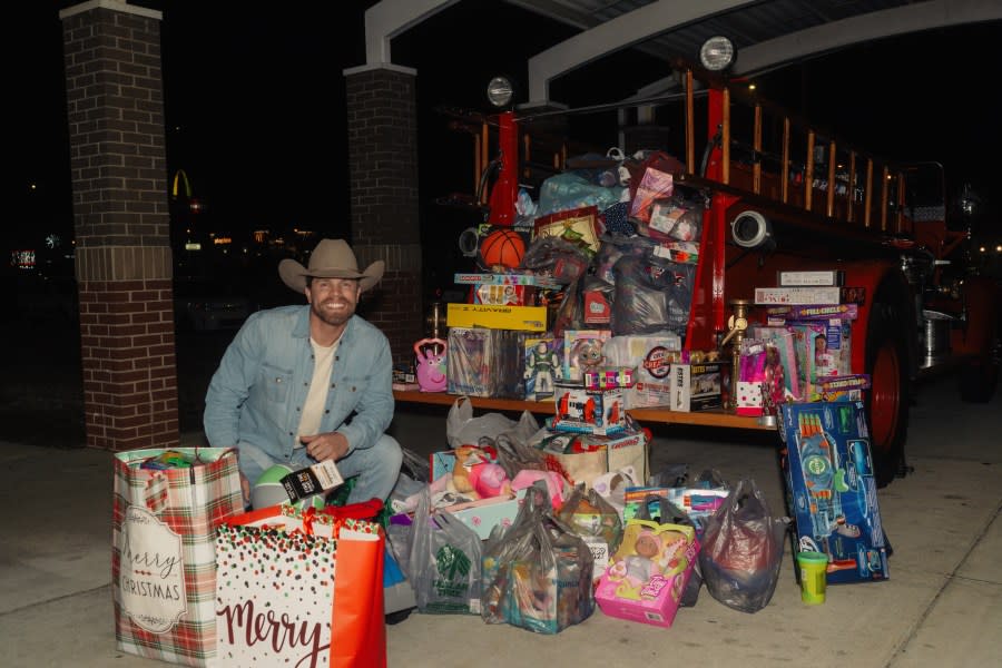 <em>Dustin Lynch shows all the toys attendees brought to the benefit concert on Dec. 12 (Photo: Jack Owens/Sweet Talk Publicity)</em>