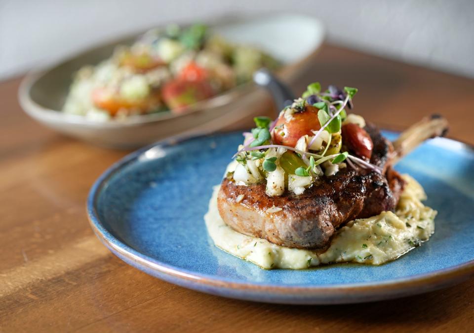 Offerings from Alqueria for 614 Restaurant Week include a smoked Cajun spiced pork loin (front) accompanied by a chimichurri potato puree and charred heirloom tomato salad, as well as a quinoa and lentil salad (back).