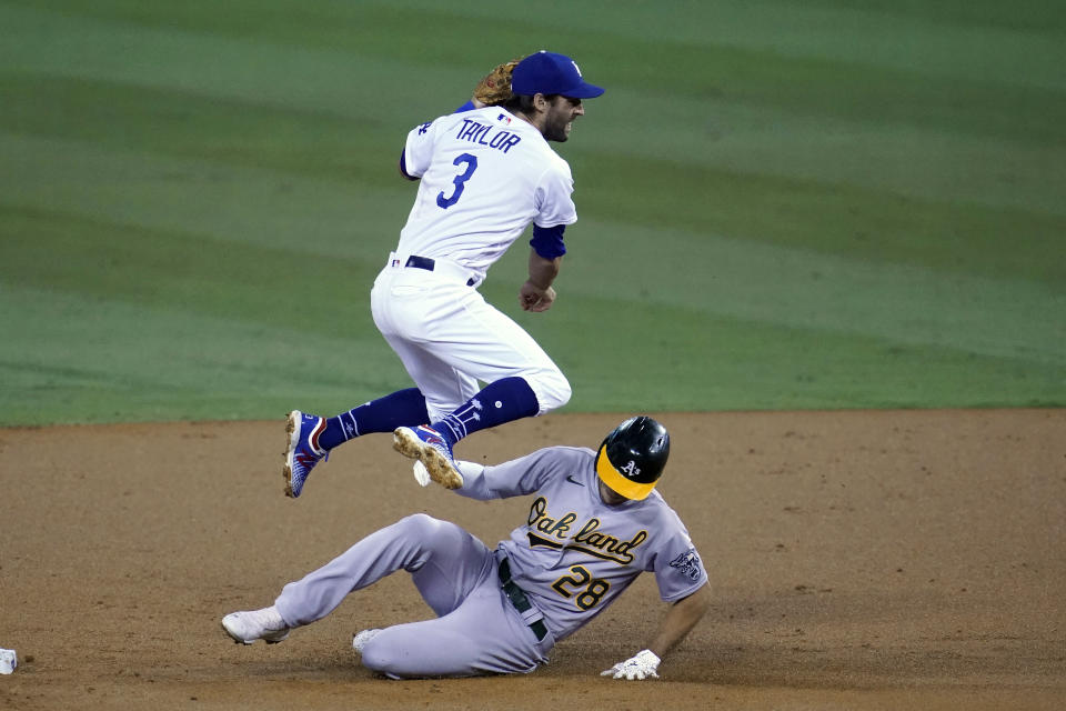 Los Angeles Dodgers second baseman Chris Taylor hops over Oakland Athletics' Matt Olson, who was forced out on a double play hit into by Ramon Laurean during the second inning of a baseball game Thursday, Sept. 24, 2020, in Los Angeles. (AP Photo/ Marcio Jose Sanchez)