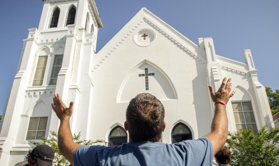 Robin Goolsby prays outside the Emanuel A.M.E. Church, Sunday, June 21, 2015, in Charleston, S.C., four days after a mass shooting at the church claimed the lives of its pastor and eight others. (AP Photo/Stephen B. Morton)