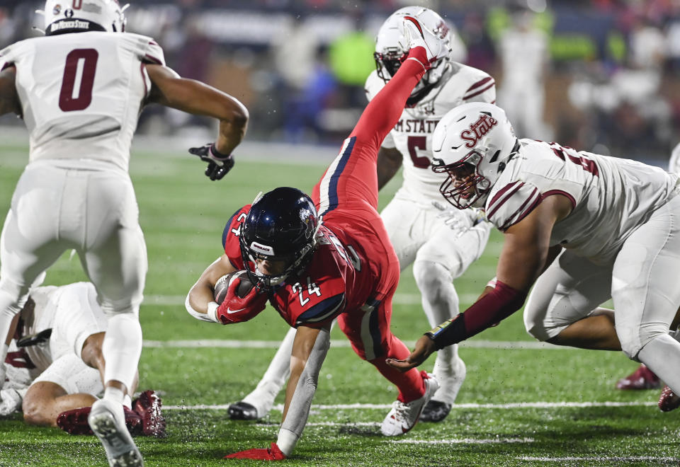 Liberty running back Vaughn Blue is tackled by New Mexico State players during the Conference USA championship NCAA college football game Friday, Dec. 1, 2023, in Lynchburg, Va. (Paige Dingler/The News & Advance via AP)