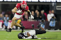 FILE - Georgia tight end Brock Bowers (19) leaps over TCU safety Millard Bradford (28) during the second half of the national championship NCAA College Football Playoff game, Monday, Jan. 9, 2023, in Inglewood, Calif. In three seasons at Georgia, Bowers caught 175 passes for 2,538 yards in 40 games and scored 31 total touchdowns with five of them coming as a runner as the Bulldogs did whatever they could to get the ball in his hands. (AP Photo/Ashley Landis, File)