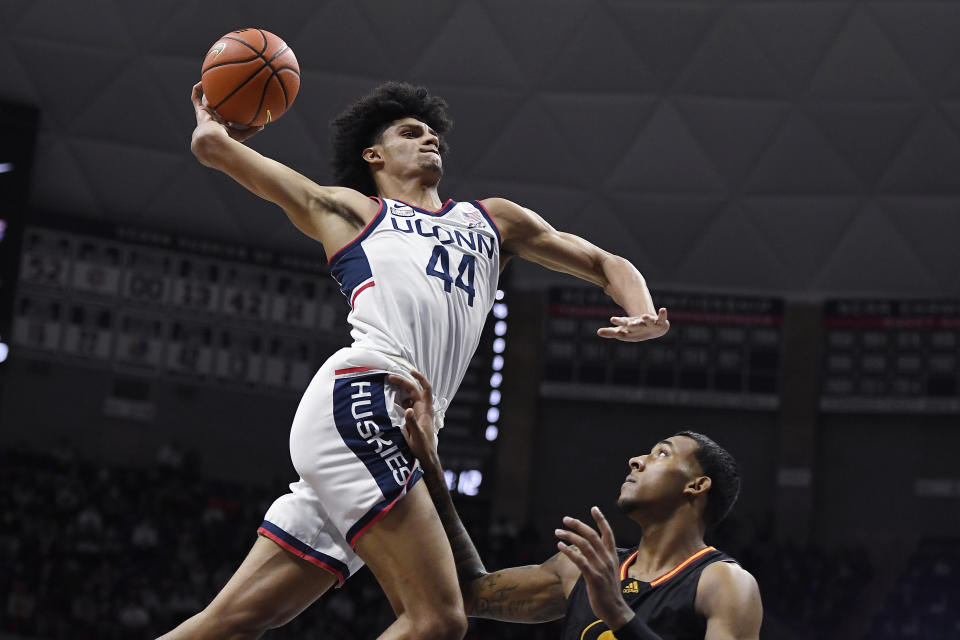 ADDS "GRAMBLING STATE'S A.J. TAYLOR DEFENDS" - Connecticut's Andre Jackson (44) winds up for a dunk as as Grambling State's A.J. Taylor defends in the first half of an NCAA college basketball game, Saturday, Dec. 4, 2021, in Storrs, Conn. (AP Photo/Jessica Hill)