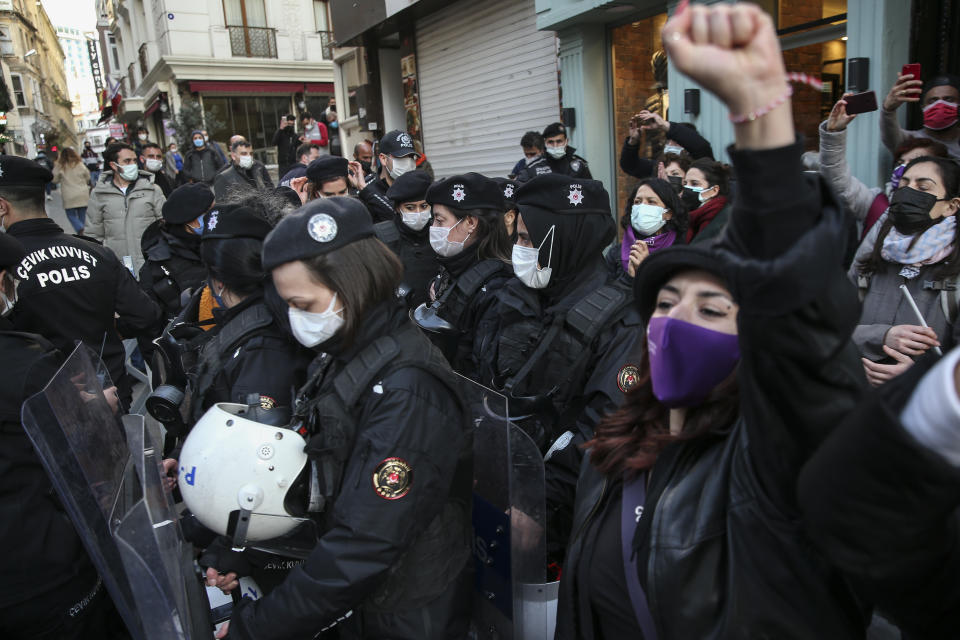 A protester chants slogans in front of police officers during a rally to mark International Women's Day in Istanbul, Monday, March 8, 2021. Thousands of people joined the march to denounce violence against women in Turkey, where more than 400 women were killed last year. The demonstrators are demanding strong measures to stop attacks on women by former partners or family members as well as government commitment to a European treaty on combatting violence against women. (AP Photo/Emrah Gurel)