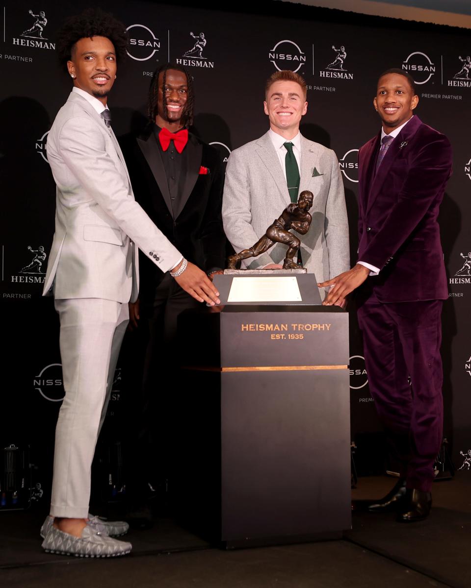 LSU Tigers quarterback Jayden Daniels, Ohio State Buckeyes wide receiver Marvin Harrison Jr., Oregon Ducks quarterback Bo Nix and Washington Huskies quarterback Michael Penix Jr. pose with the Heisman Trophy during a press conference in the Astor ballroom at the New York Marriott Marquis before the presentation of the Heisman Trophy Dec 9, 2023, in New York.