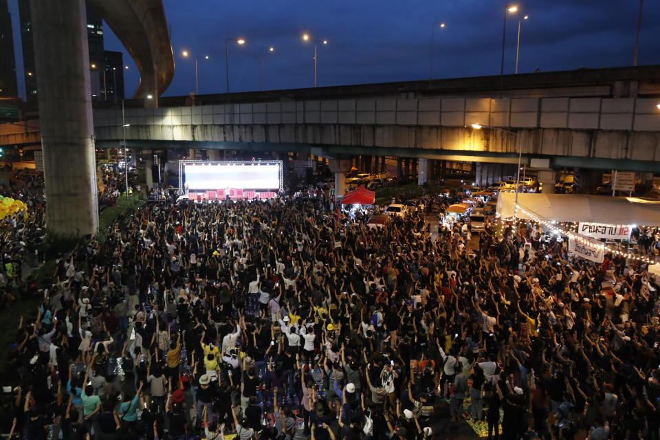 Anti-government protesters flash the three finger protest gesture during a rally Wednesday, Dec. 2, 2020, in Bangkok, Thailand. Thailand's highest court Wednesday acquitted Prime Minister Prayuth Chan-ocha of breaching ethics clauses in the country's constitution, allowing him to stay in his job. (AP Photo/Sakchai Lalit)