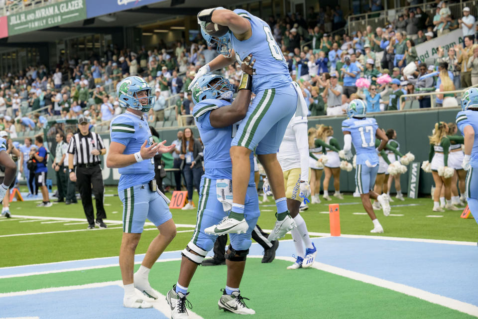 Tulane tight end Alex Bauman (87) celebrates a touchdown against Tulsa with quarterback Michael Pratt, left, and offensive lineman Sincere Haynesworth, center, during the first half an NCAA college football game in New Orleans, Saturday, Nov. 11, 2023. (AP Photo/Matthew Hinton)