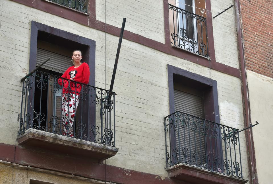 Une personne atteinte du coronavirus et placée en confinement prend l'air sur son balcon. - ANDER GILLENEA / AFP

