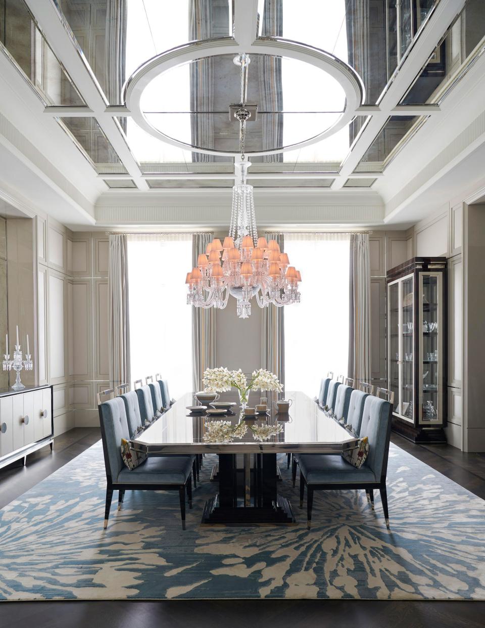 In the dining room, a 12-person table is surrounded by velvet chairs, all by Rafauli. Baccarat chandelier.