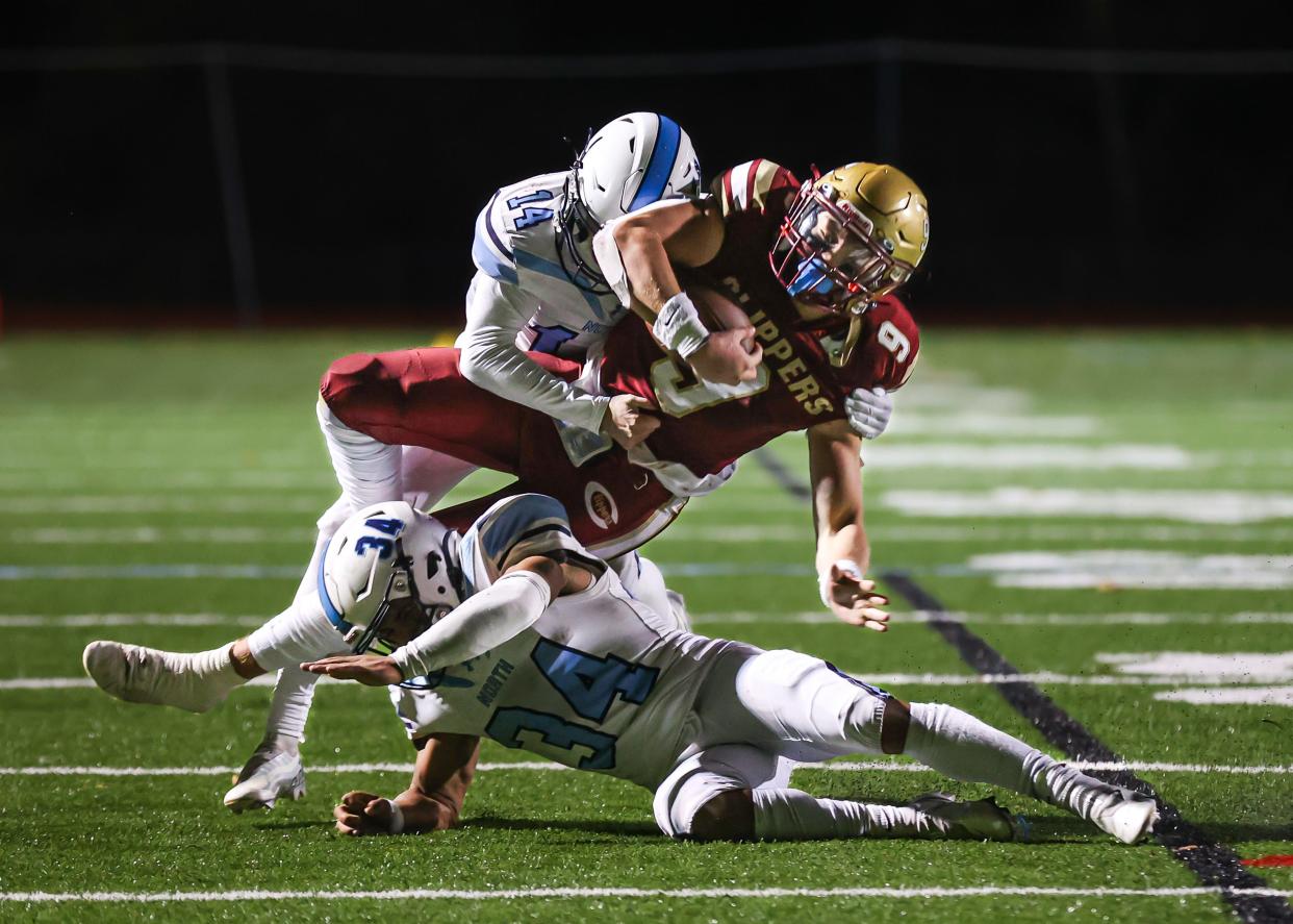 Portsmouth's Brooks Connors is tackled by Nashua North's Dylan Noble (14) and Steven Rosario (34) during last Friday's Division I quarterfinal game at Tom Daubney Field.