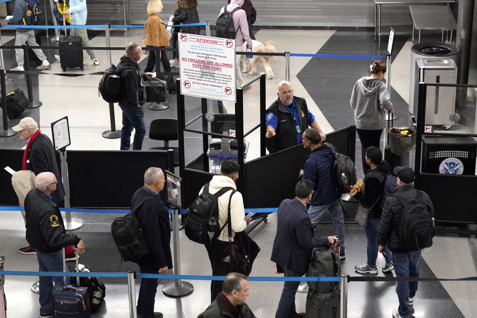 Travelers line up at a security checkpoint area in Terminal 3 at the O'Hare International Airport in Chicago, Thursday, Dec. 21, 2023. It's beginning to look a lot like a hectic holiday travel season, but it might go relatively smoothly if the weather cooperates. (AP Photo/Nam Y. Huh)