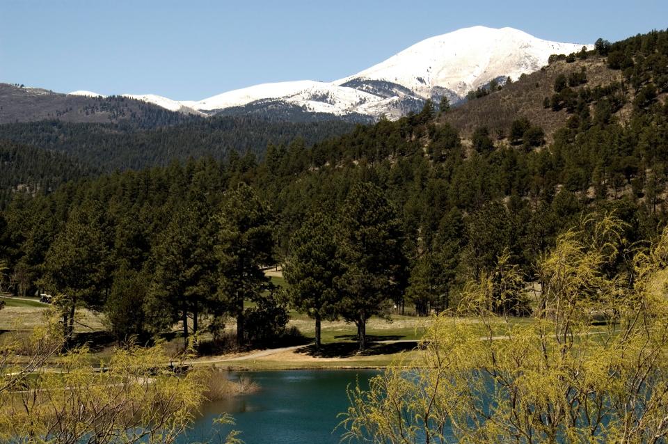 A lake in Ruidoso, New Mexico with ski-covered mountains captured in the background