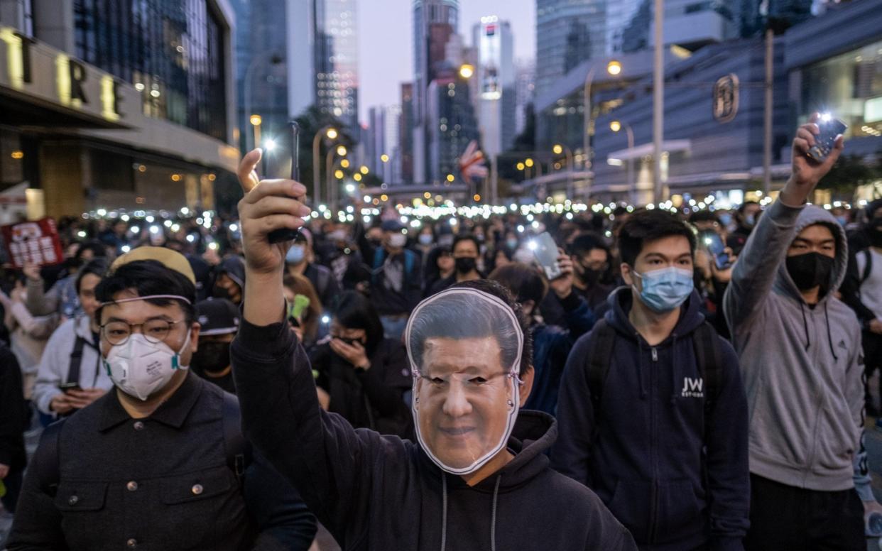 A demonstrator wearing a face mask featuring Chinese President Xi Jinping joined hundreds of thousands in pro-democracy demonstrations - Bloomberg
