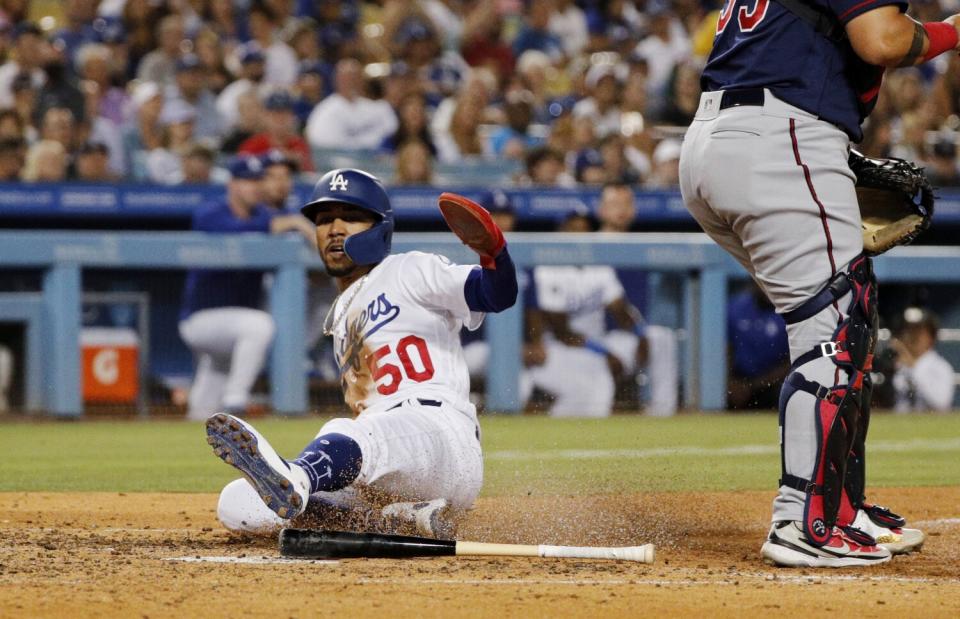 Dodgers right fielder Mookie Betts slides safely into home plate.