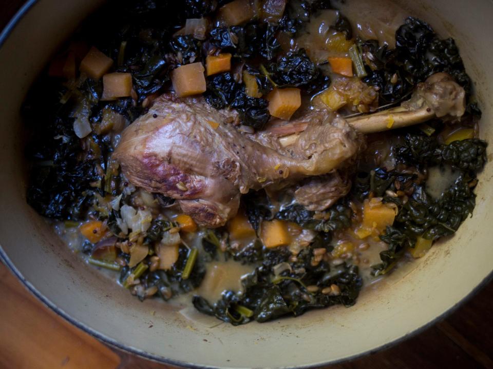 turkey leg and vegetables braising in a pot