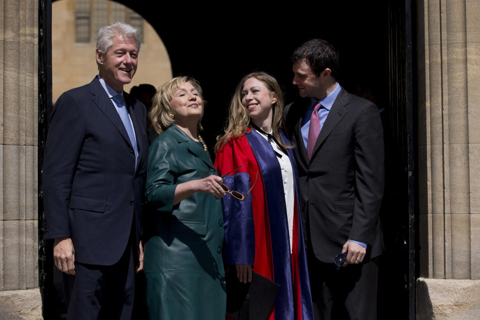 Former U.S. Secretary of State Hillary Rodham Clinton, second left, takes off her sunglasses to pose for a group photograph with her husband former U.S. President Bill Clinton, left, their daughter Chelsea, second right, and her husband Marc Mezvinsky, as they leave after they all attended Chelsea's Oxford University graduation ceremony at the Sheldonian Theatre in Oxford, England, Saturday, May 10, 2014. Chelsea Clinton received her doctorate degree in international relations on Saturday from the prestigious British university. Her father was a Rhodes scholar at Oxford from 1968 to 1970. The graduation ceremony comes as her mother is considering a potential 2016 presidential campaign. (AP Photo/Matt Dunham)