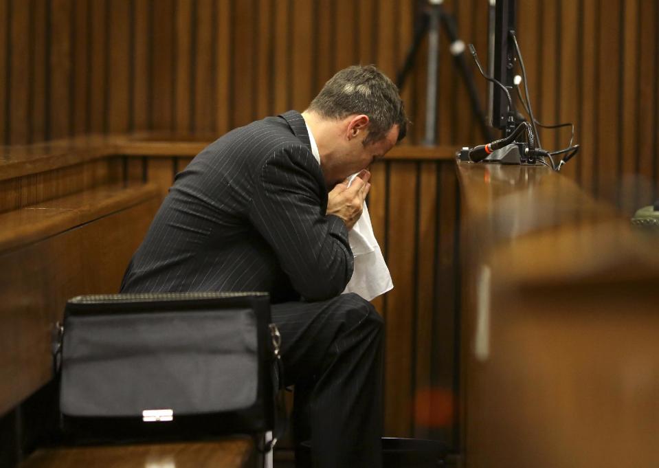 Oscar Pistorius blows his nose after reaching for a bucket as he listened to cross questioning about the events surrounding the shooting death of his girlfriend Reeva Steenkamp, in his second week in court during his trial in Pretoria, South Africa, Monday, March 10, 2014. Pistorius is charged with the shooting death of his girlfriend Steenkamp, on Valentines Day in 2013. (AP Photo/Siphiwe Sibeko, Pool)