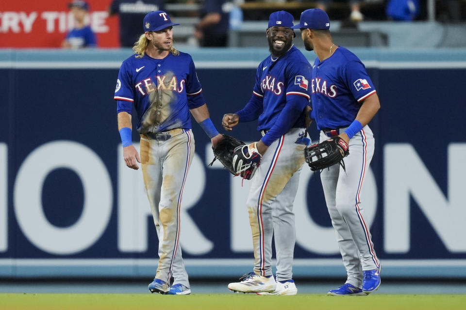 Texas Rangers outfielders Travis Jankowski, Adolis Garcia and Leody Taveras, from left, celebrate the team's win over the Los Angeles Dodgers in a baseball game Thursday, June 13, 2024, in Los Angeles. (AP Photo/Ryan Sun)