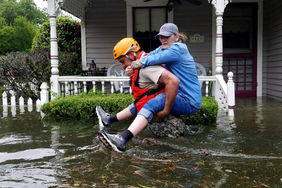 In this photo&nbsp;provided by the Army National Guard, a Texas National Guardsman carries a resident from her flooded home following Hurricane Harvey on Aug. 27 in Houston. (Photo: Lt. Zachary West/Army National Guard via Getty Images)