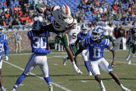 Miami wide receiver Jacolby George (15) gets upended as he tries to hurdle over Duke safeties Brandon Johnson (30) and Isaiah Fisher-Smith (11) on a punt return during the first half of an NCAA college football game Saturday, Nov. 27, 2021, in Durham, N.C. (AP Photo/Chris Seward)