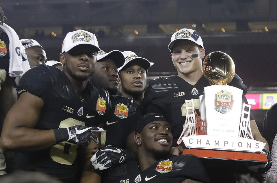 Purdue quarterback Elijah Sindelar, top right, holds the trophy next to teammates after their 38-35 win over Arizona in the Foster Farms Bowl. (AP Photo/Marcio Jose Sanchez)