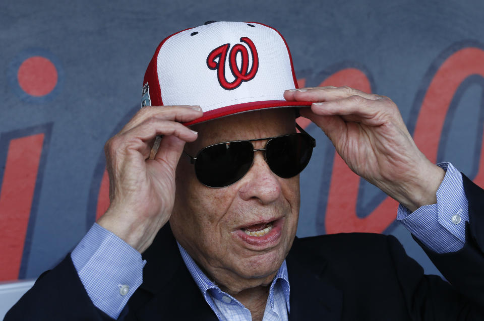 FILE - In this Feb. 28, 2017, file photo, Washington Nationals owner Ted Lerner tries on a baseball cap before a ribbon cutting ceremony to open The Ballpark in West Palm Beach, Fla. Washington Nationals founder Ted Lerner has died. He was 97. Lerner bought the team from Major League Baseball in 2006 for $450 million. He was managing principal owner until ceding that role to son Mark in 2018. (AP Photo/John Bazemore, File)