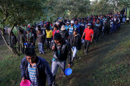 FARC members walk to get breakfast in a camp near the transitional zone of Pueblo Nuevo, Colombia, February 5, 2017. REUTERS/Federico Rios