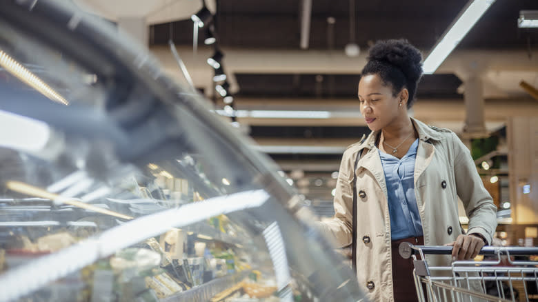 woman browsing glass deli case