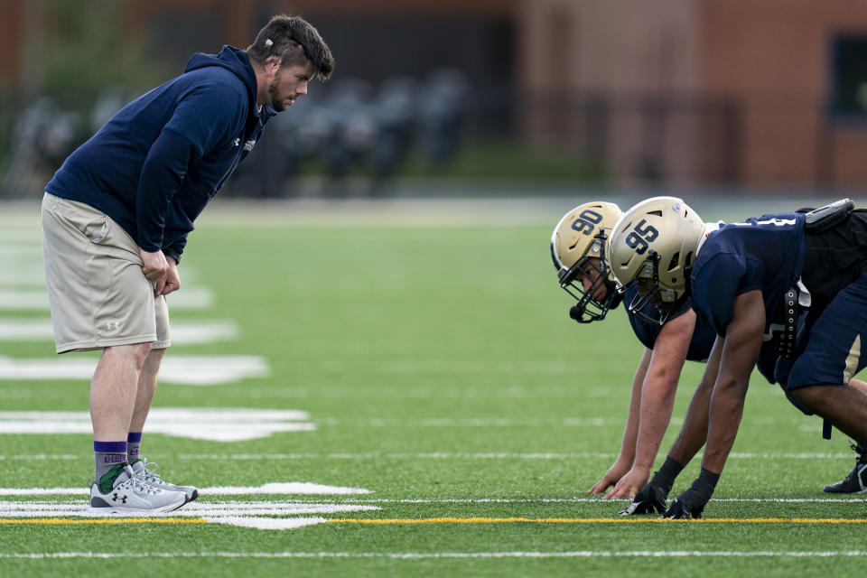 Gallaudet assistant coach Shelby Bean, left, coaches players during football practice at Hotchkiss Field, Tuesday, Oct. 10, 2023, in Washington. (AP Photo/Stephanie Scarbrough)