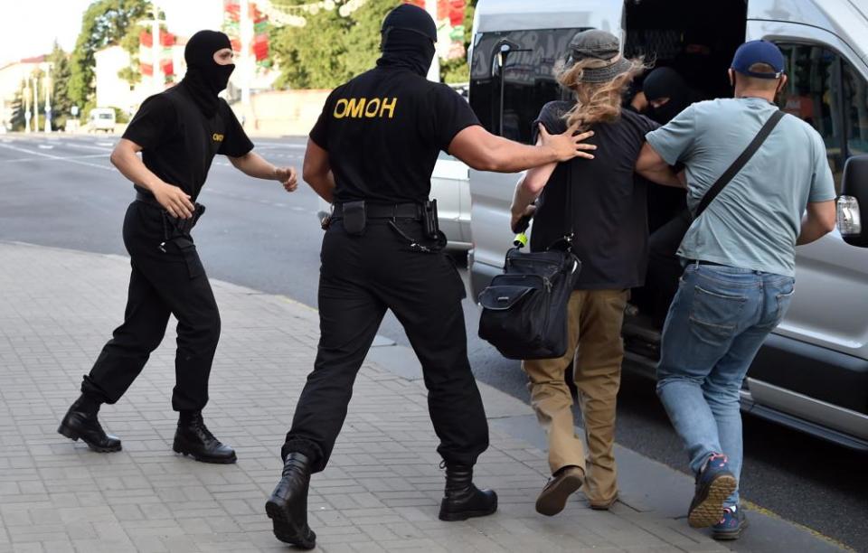 Belarus riot police detain a man on Saturday during an opposition rally on the eve of the presidential election in central Minsk.