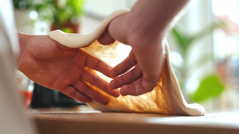 Chef stretching pizza dough