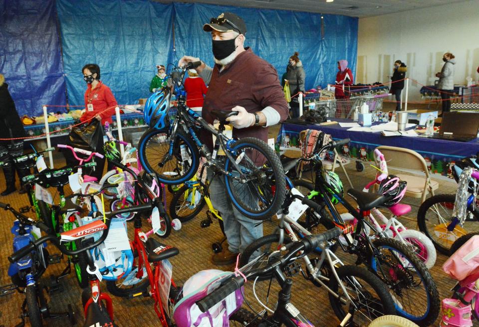 Volunteer Paul Brown of Killingly, who donated 60 bicycles, lifts one at a previous Tommy Toy Fund distribution at Killingly Commons. File photo