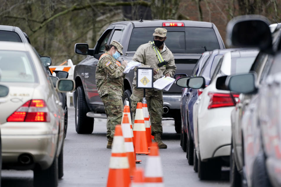 National Guard personnel check in people as they wait to receive a COVID-19 vaccination Feb. 26, 2021, in Shelbyville, Tenn. Tennessee has continued to divvy up vaccine doses based primarily on how many people live in each county, and not on how many residents belong to eligible groups within those counties. (AP Photo/Mark Humphrey, File)