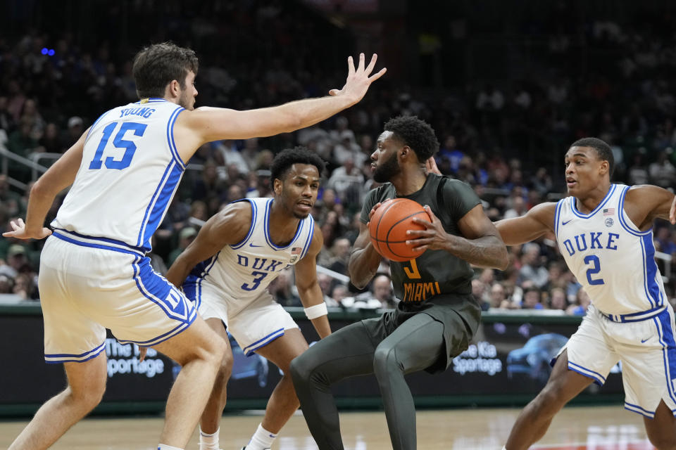Miami guard Wooga Poplar, center, looks for an opening past Duke players during the second half of an NCAA college basketball game, Wednesday, Feb. 21, 2024, in Coral Gables, Fla. Duke players from left: Ryan Young, Jeremy Roach, and Jaylen Blakes. (2)(AP Photo/Wilfredo Lee)