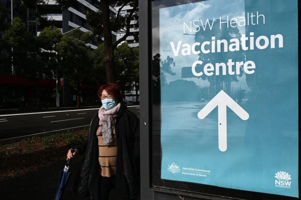 A woman walks past the vaccination centre signage in Sydney.