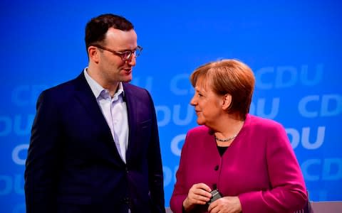 Angela Merkel was forced to bring the conservative Jens Spahn into her cabinet in order to win backing for a new coalition - Credit: AFP