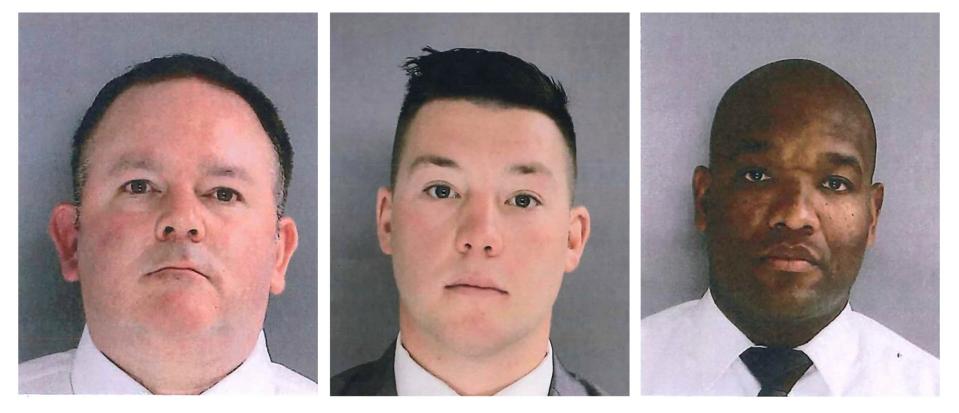 In this photo provided by the Delaware County District Attorney's Office on Tuesday, Jan. 18, 2022, Sharon Hill Police officers Brian Devaney, left, Sean Dolan, and Devon Smith are shown. The three police officers have been charged with manslaughter and reckless endangerment after firing their weapons into a crowd of people exiting a high school football game outside of Philadelphia, killing 8-year-old Fanta Bility and injuring three people.