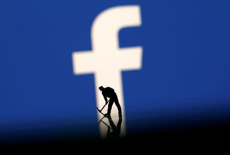 A figurine is seen in front of the Facebook logo in this illustration taken, March 20, 2018. REUTERS/Dado Ruvic