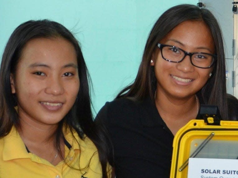 Solimene and Nguyen pose with the lighting unit they donated to a birthing center in Vietnam