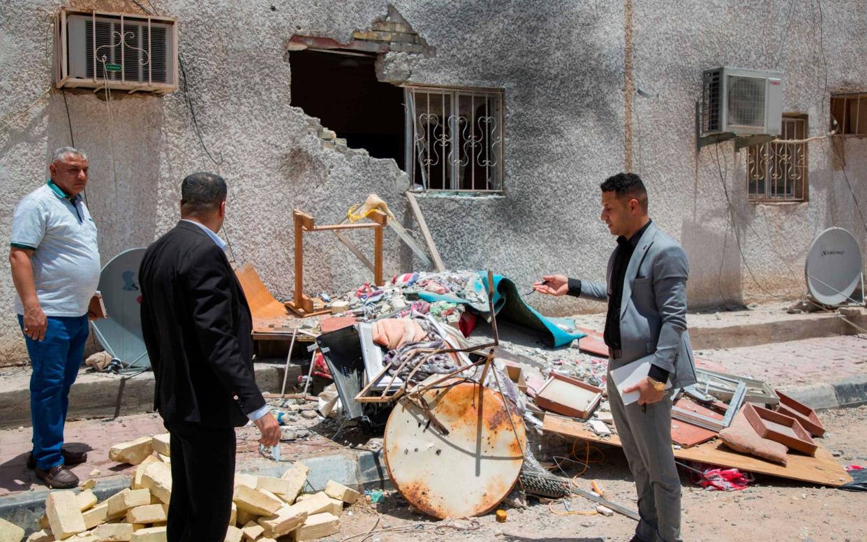 Iraqis inspect the damage at the drilling facility that was hit with a rocket - AFP