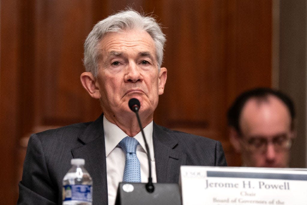 Jerome Powell sits at a lectern