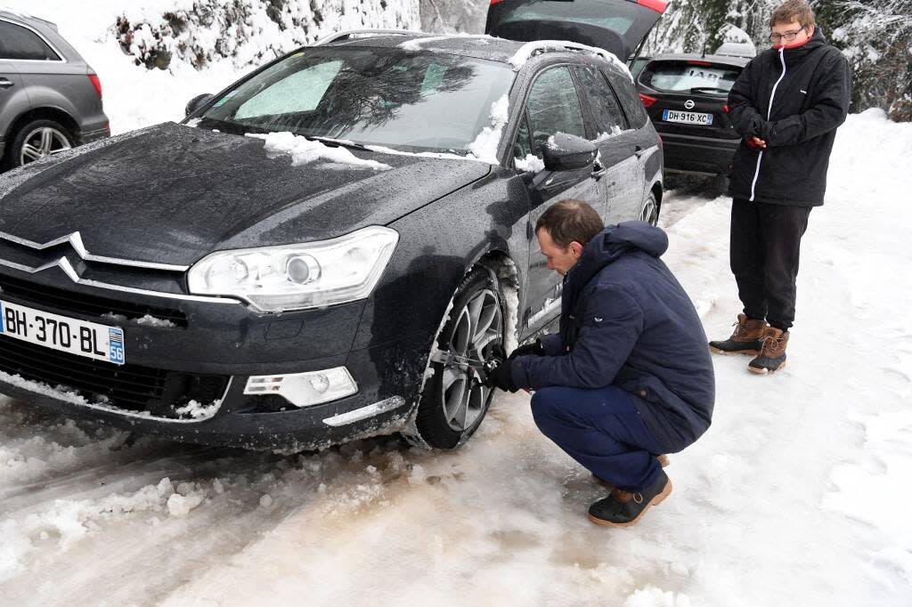 Photo d’illustation d’automobilistes qui installent des chaînes à neige sur les pneus de leur voiture à Beaufort, dans le centre-est de la France, alors qu’ils se rendent dans les stations de ski des Alpes françaises. 