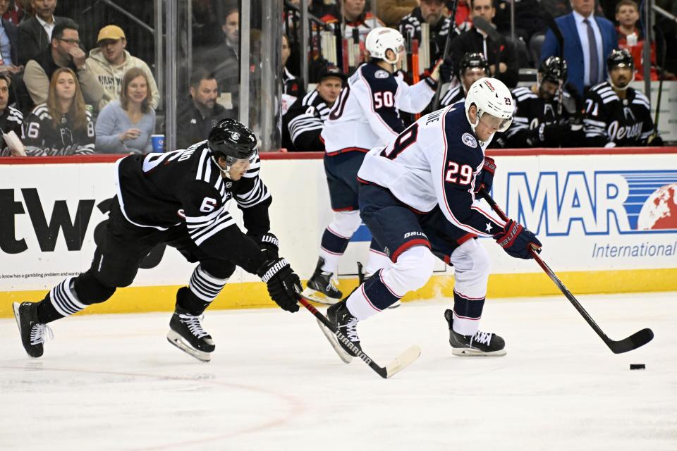 Columbus Blue Jackets right wing Patrik Laine (29) skates with the puck as he is pursued by New Jersey Devils defenseman John Marino (6) during the first period of an NHL hockey game Friday, Nov. 24, 2023, in Newark, N.J. (AP Photo/Bill Kostroun)