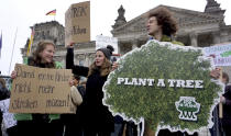 Students protest under the banner of 'Fridays for Future' in front of the Reichstag building, host of the German Federal Parliament, in Berlin, Germany, Friday, Dec. 14, 2018 against the climate change. Slogan on the left reads 'So my children don't heve to strike anymore'. (AP Photo/Michael Sohn)